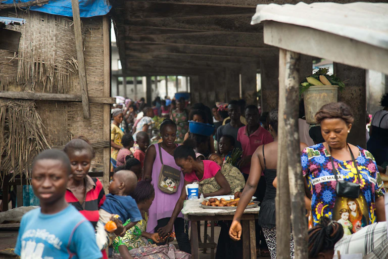 Des personnes vendent et viennent acheter des aliments dans un marché en République démocratique du Congo.