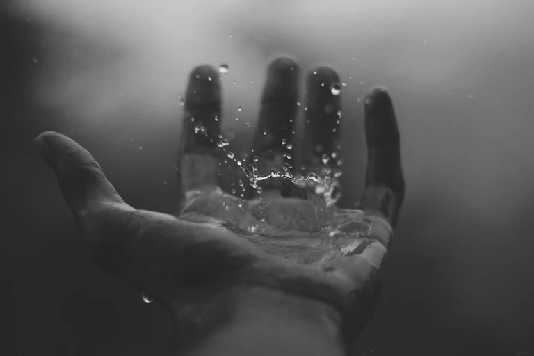 Une main recevant une goutte d'eau.