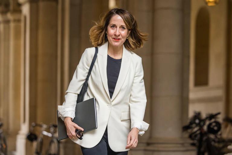 Liz Kendall walking in whitehall carrying a black folder.