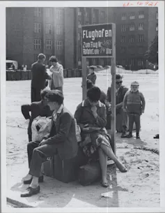 Un groupe de réfugiés est-allemands assis sur un banc, archive de 1961