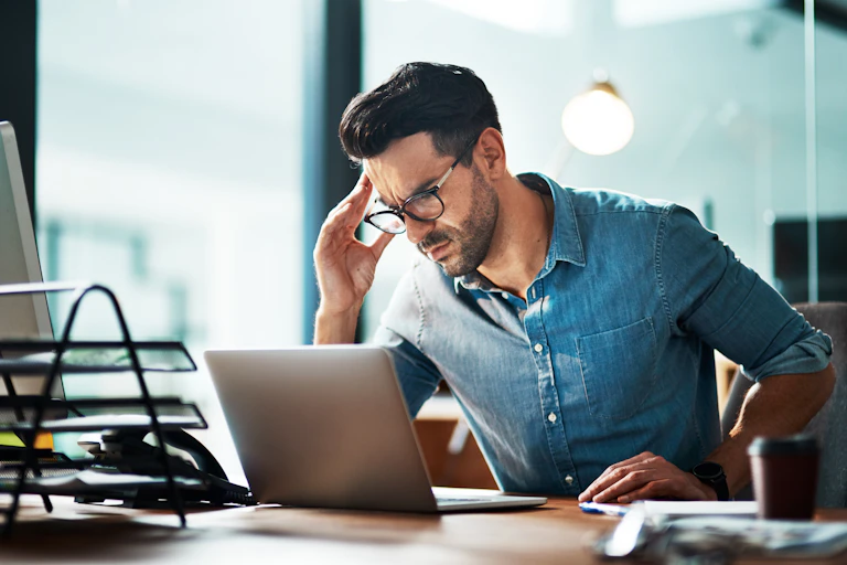 worried man looking at a laptop