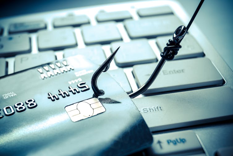 phishing hook with credit card and computer keyboard