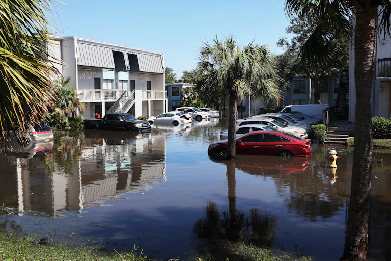 Cars parked outdoors at an apartment complex, submerged up to their bumpers