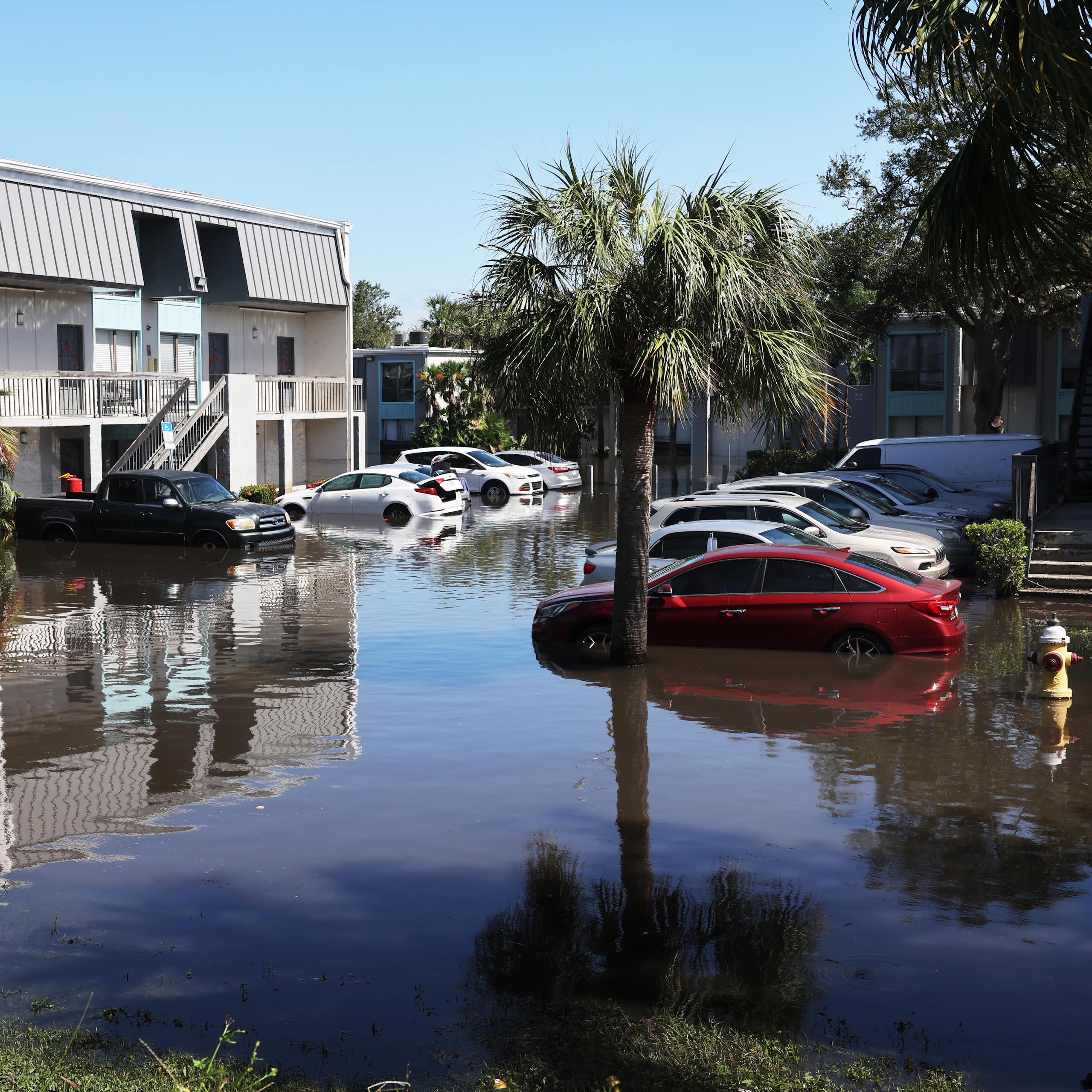 Cars parked outdoors at an apartment complex, submerged up to their bumpers