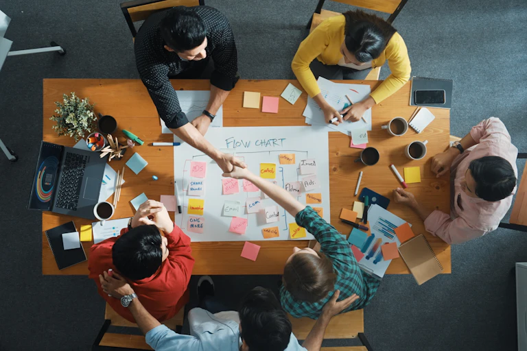 Overhead shot of a group of people sitting around and working at a conference table