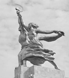 A sculpture of a man and woman holding a hammer and sickle.