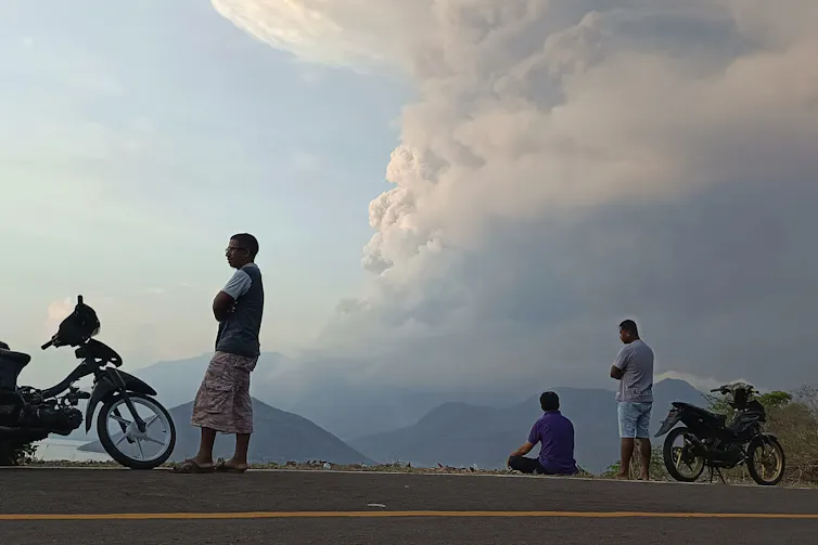 Residents watch as Mount Lewotobi Laki Laki volcano spews volcanic materials during an eruption in East Flores, Indonesia