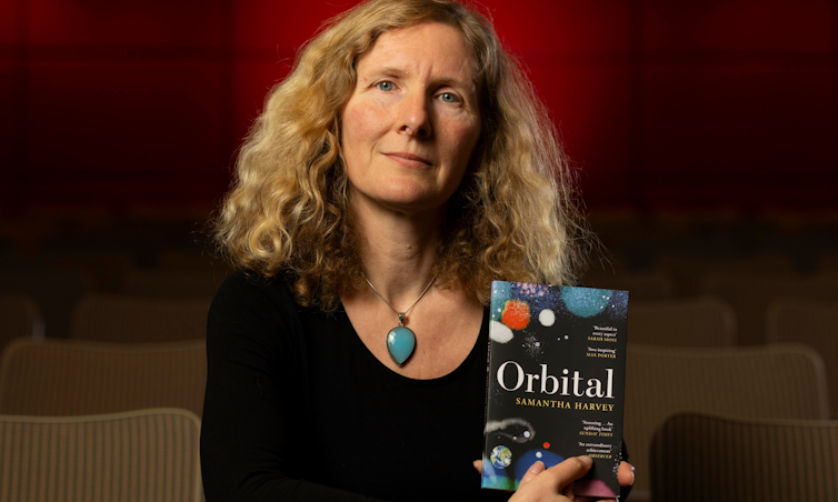 Samantha Harvey poses with her book