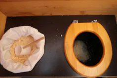 A dry toilet with a scoop and woodchip next to it which is used after toileting instead of flushing.