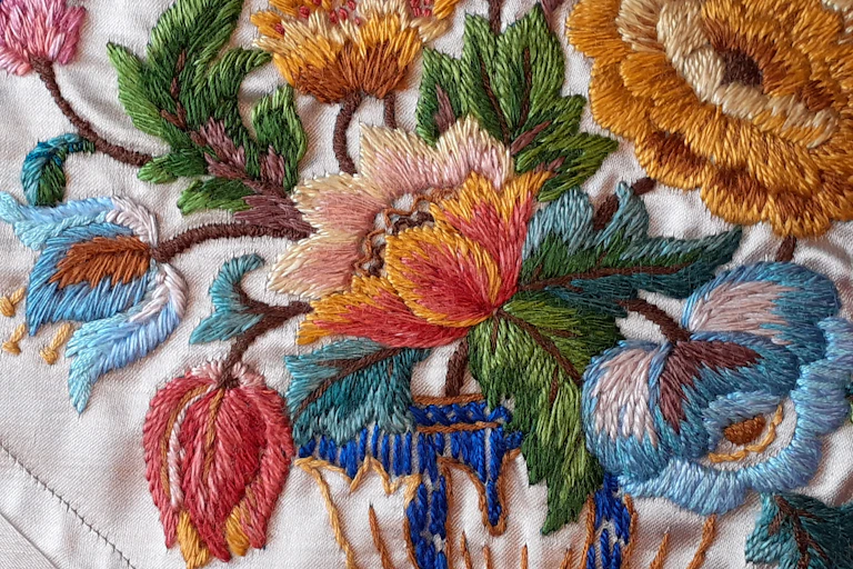 A beautifully embroidered table runner with fine flower detail.