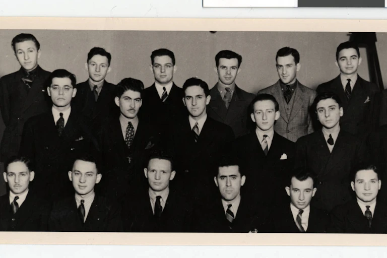 Three rows of young men in suits and ties.