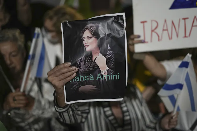 Un individu tient une affiche sur laquelle apparait une femme