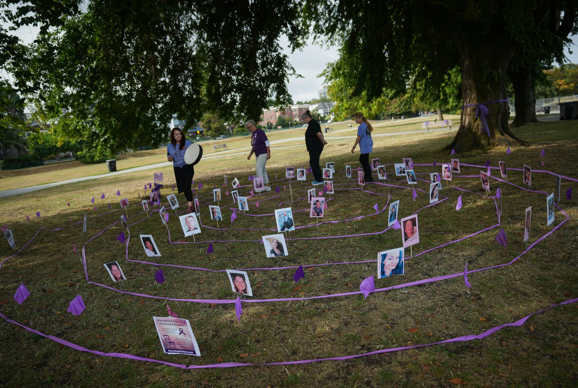 People participate in a ceremony and walk among photographs.