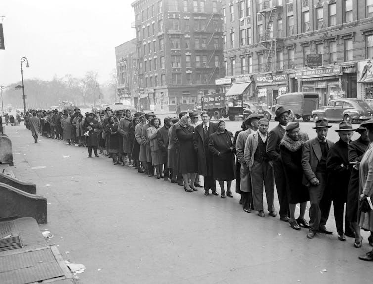 Multicultural voters form a long line outside a polling station.