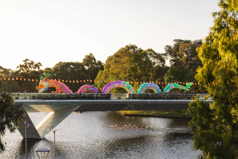 A dragon on a bridge, surrounded by gum trees.