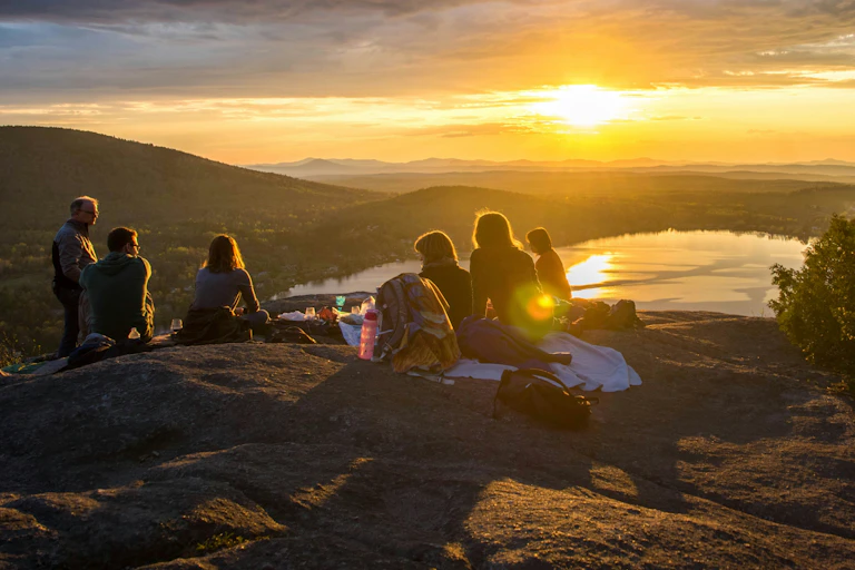 People watch the sunset at a picnic