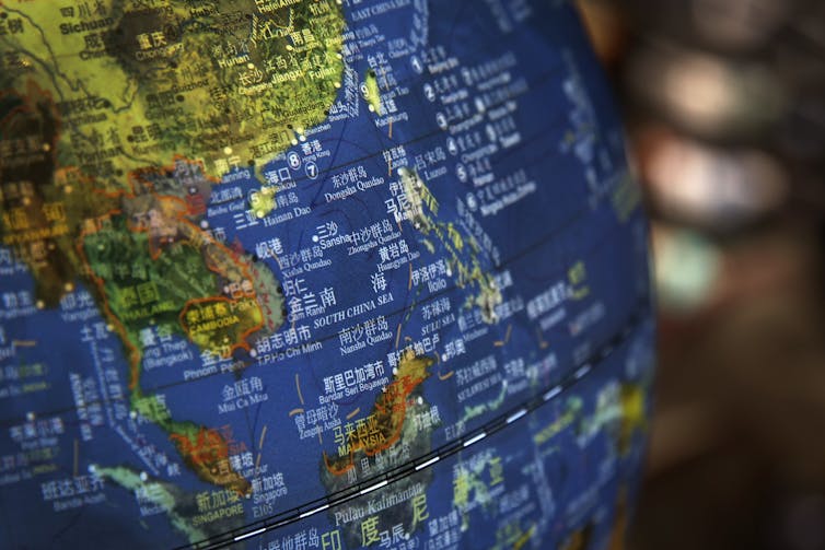A globe shows Chinese writing over various islands.