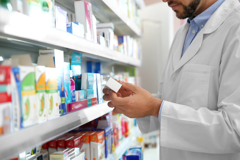 Un pharmacien regarde un boîte de médicament.