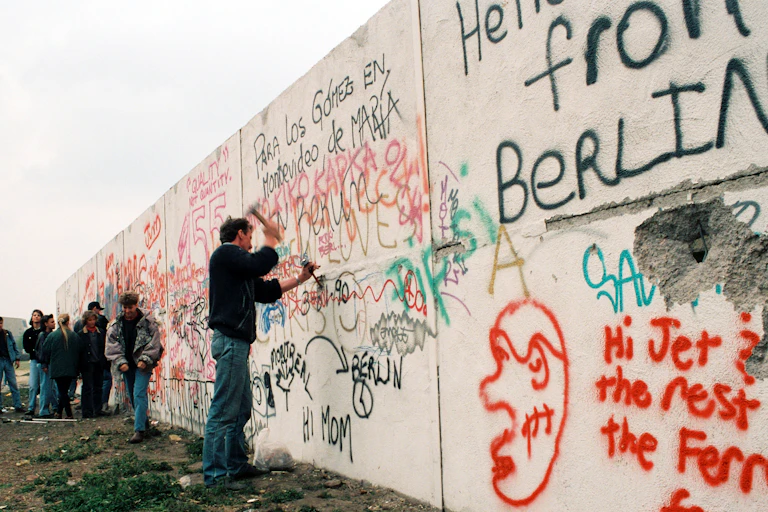 Un homme frappe au marteau une partie du mur de Berlin