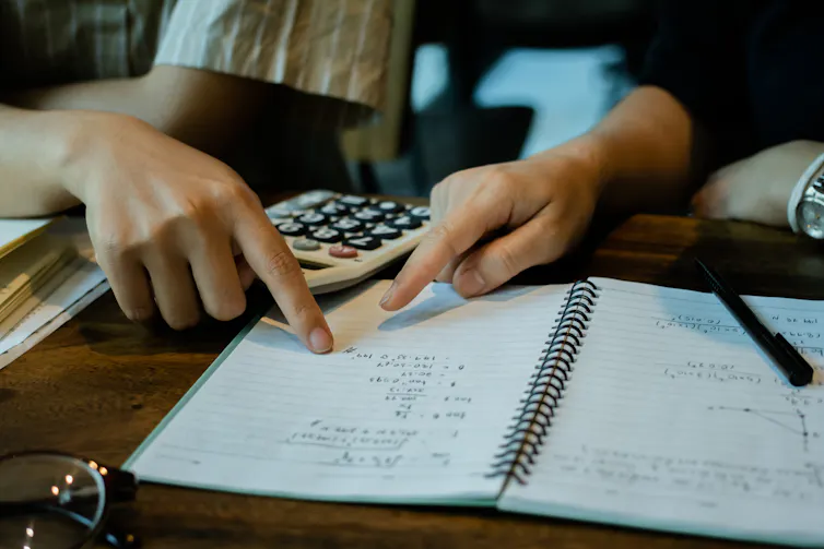 Hands pointing at maths homework