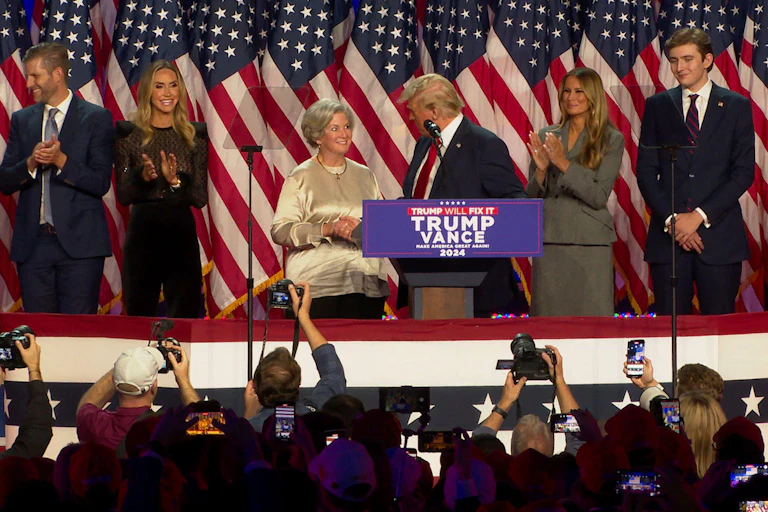Donald Trump shakes hands with Susie Wiles on stage at an eleciton watch party in Florida, November 6 2024.