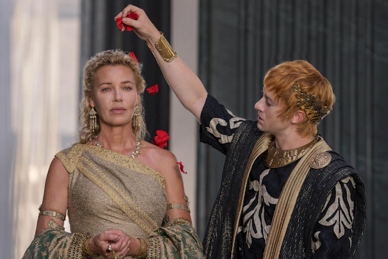 A Roman man sprinkles rose petals on a woman
