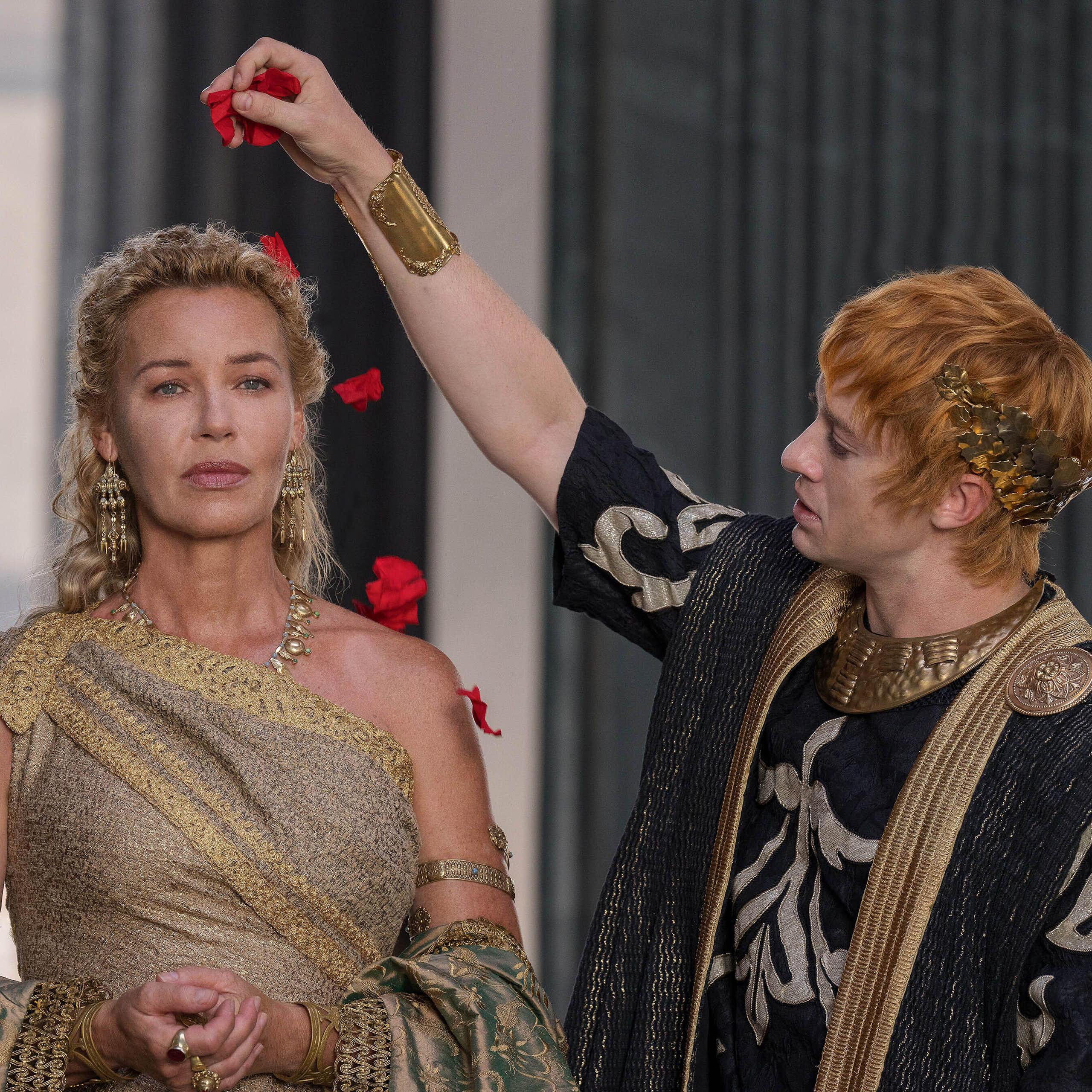 A Roman man sprinkles rose petals on a woman