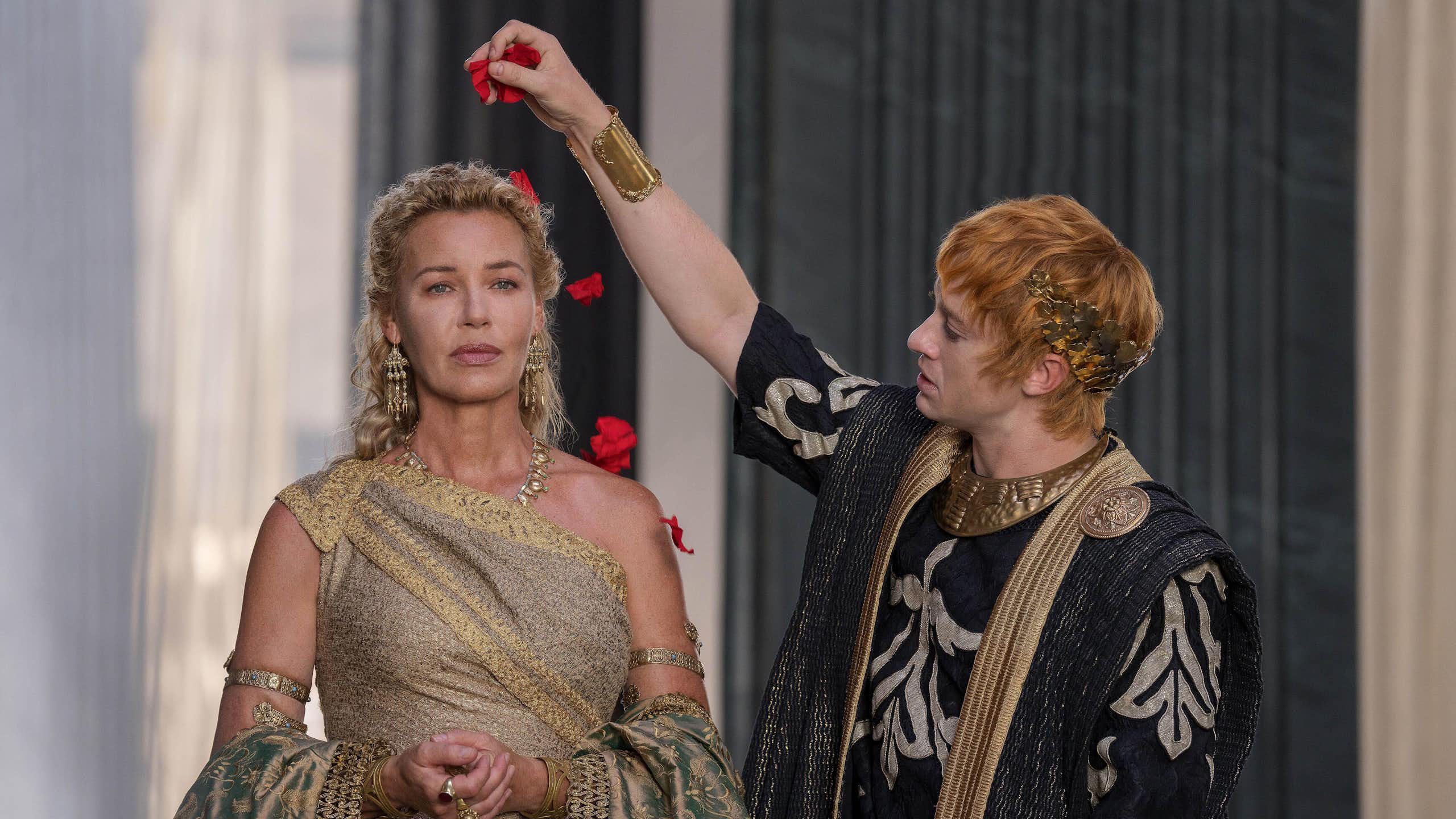 A Roman man sprinkles rose petals on a woman