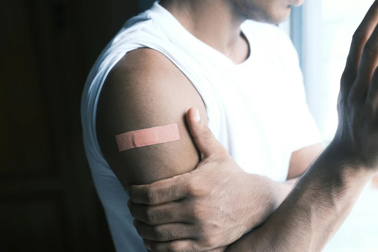 A person with a bandaid on their upper arm.