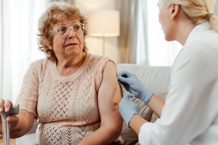 A woman receives a vaccine.