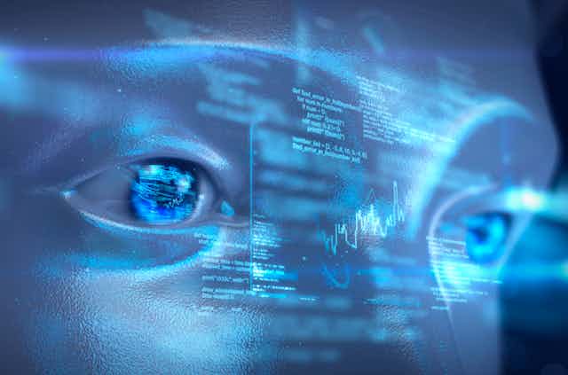 An artificial intelligence robot looks at a digital data display.
