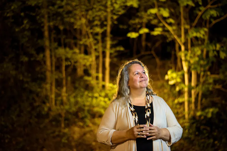Author Robin standing with hands held together in woodland