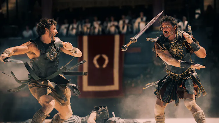 Two roman gladiators in leather armour fighting in the Colosseum.