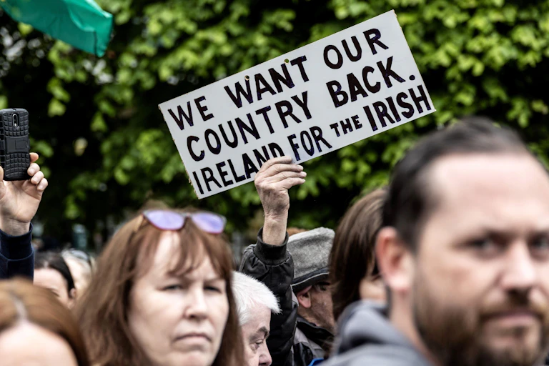 A protestor holding a sign that reads 'we want our country back. Ireland for the Irish