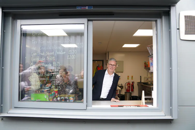 Keir Starmer looking out of the window of a portacabin.