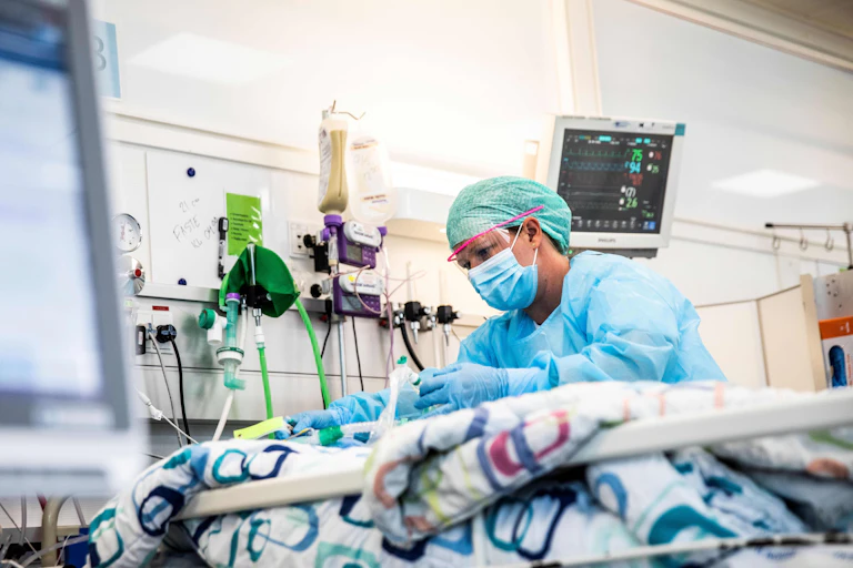 A nurse tends to a COVID patient at hospital