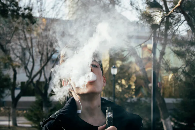 A person vaping outdoors.