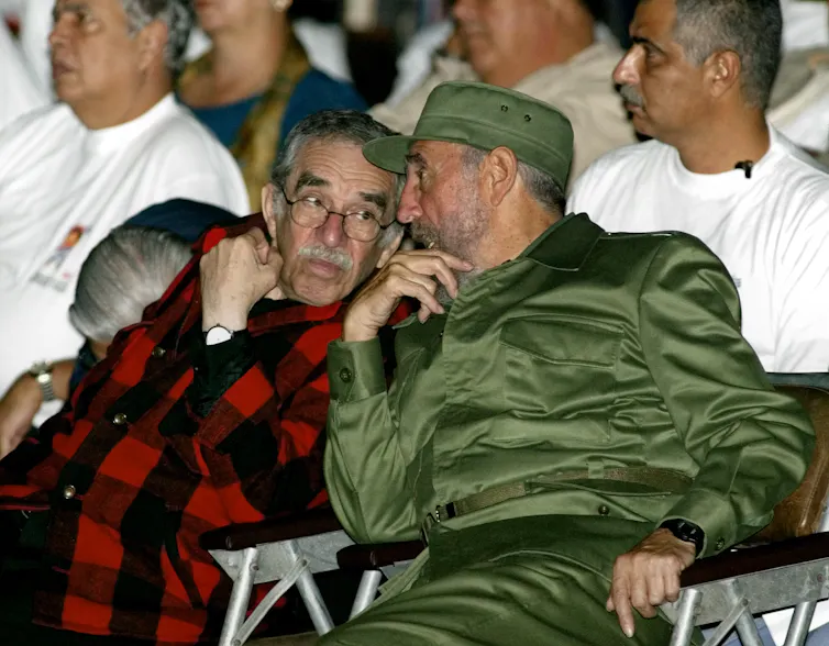 Dos hombres conversando en una reunión política.