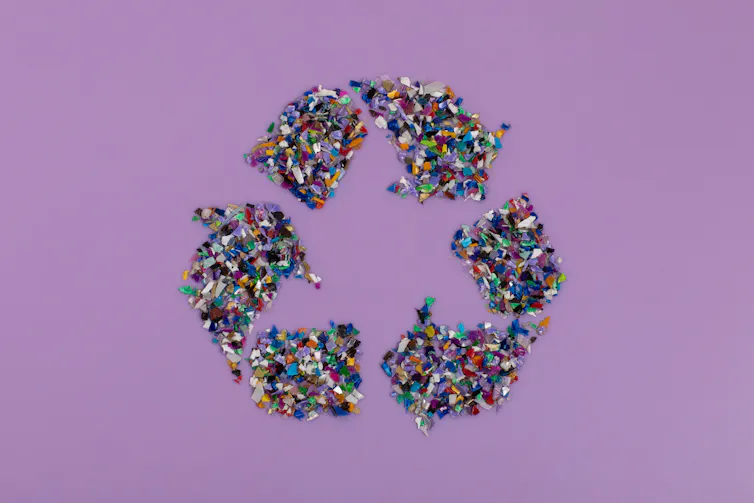 purple background, recycling symbol made of coloured plastic fragments