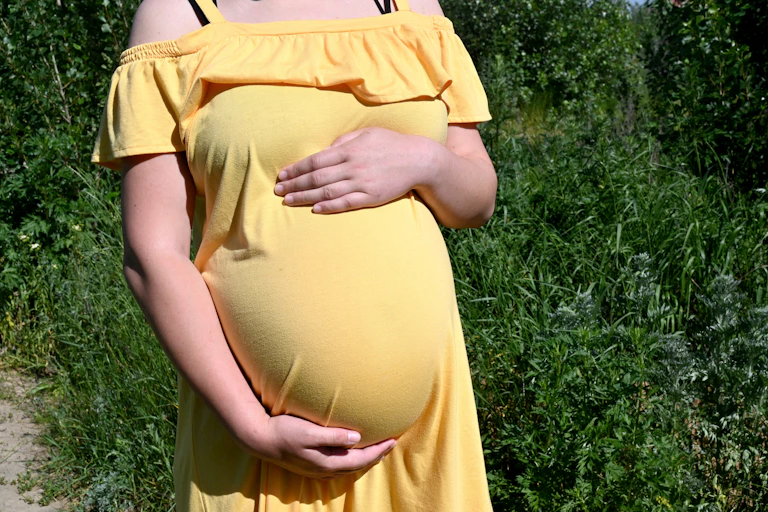Sur cette photo prise le 12 juin 2020, Olga, une jeune femme de 26 ans qui en est à sa deuxième gestation pour autrui et qui attend des jumeaux pour un couple chinois, se tient le ventre en marchant dans la petite ville de Sophiya Borshchagivka, près de Kiev.