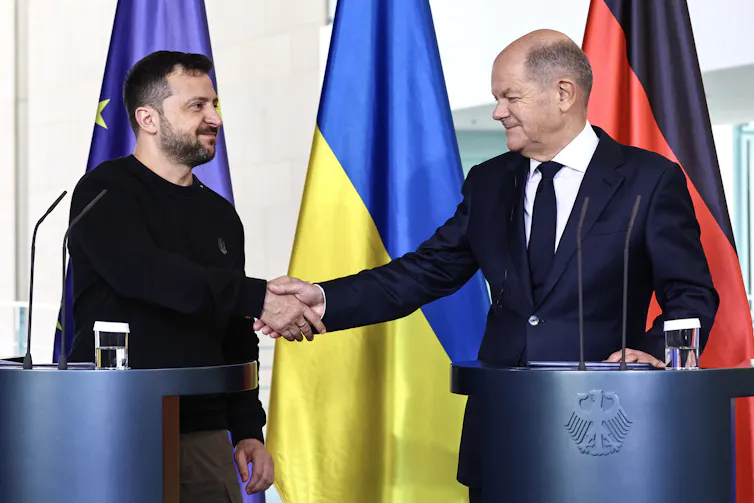 Olaf Scholz and Volodymyr Zelensky shaking hands.