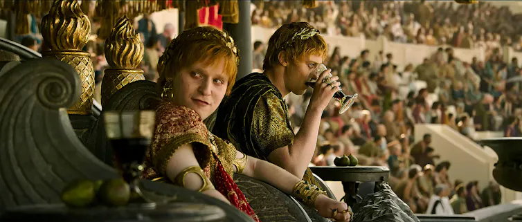 Fred Hechinger and Joseph Quinn in Gladiator II watching combat from the stands
