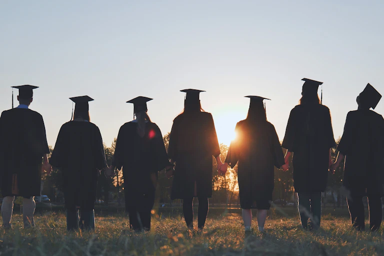 A group of graduates holding hands.