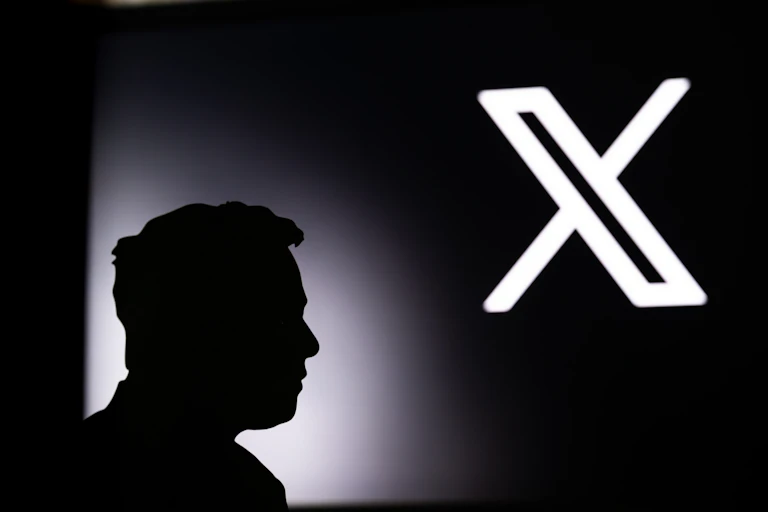 Silhouette of man standing in front of the X logo.