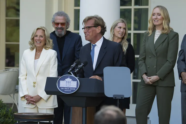 A suntanned man at a podium.