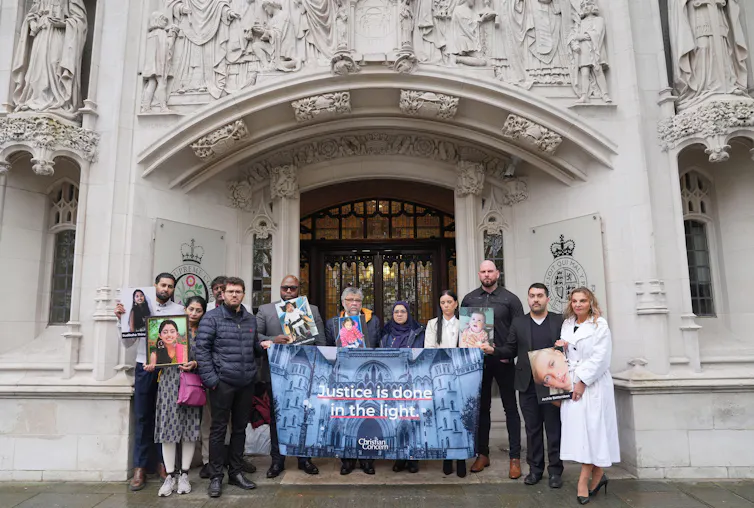 The family of Sudiksha Thirumalesh stand with another family outside the Supreme Court in London.