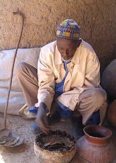 A Cameroonian man looking at crabs