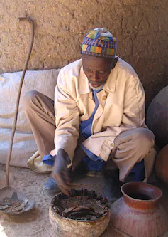 A Cameroonian man looking at crabs