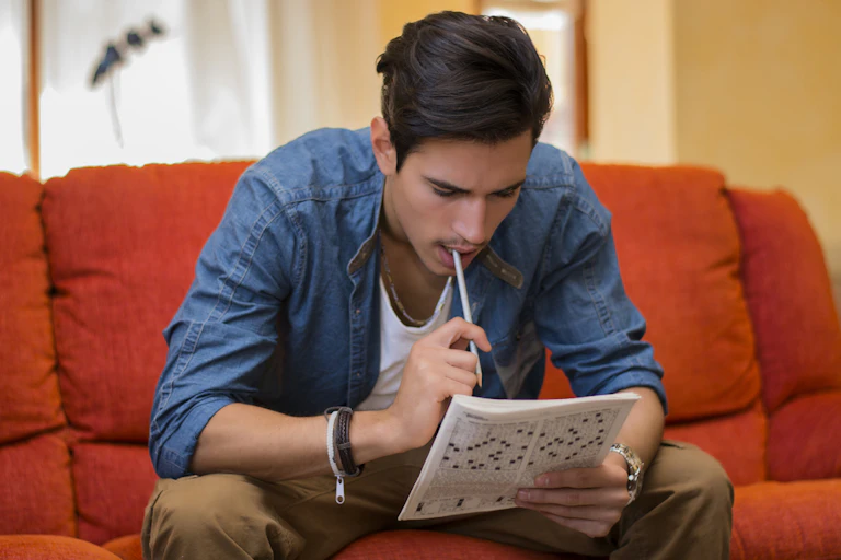 jeune homme faisant des mots croisés
