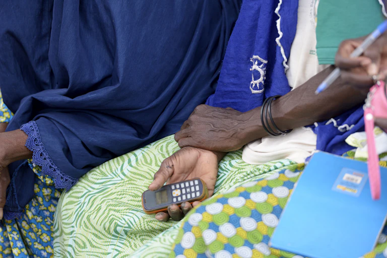 A seated woman holding a cellphone